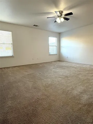 an empty room with windows and fan
