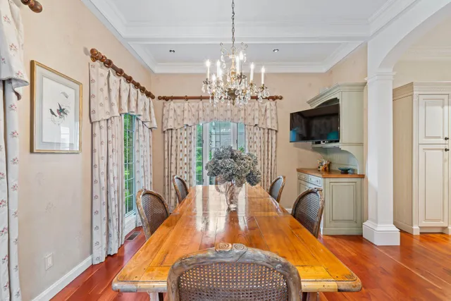 a view of a dining room with furniture a chandelier and wooden floor
