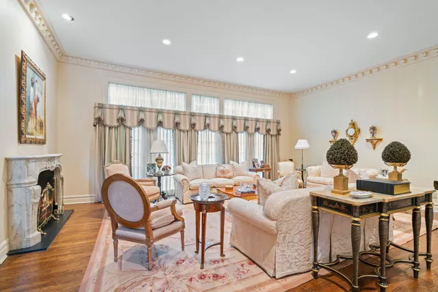 a living room with fireplace furniture and a large window