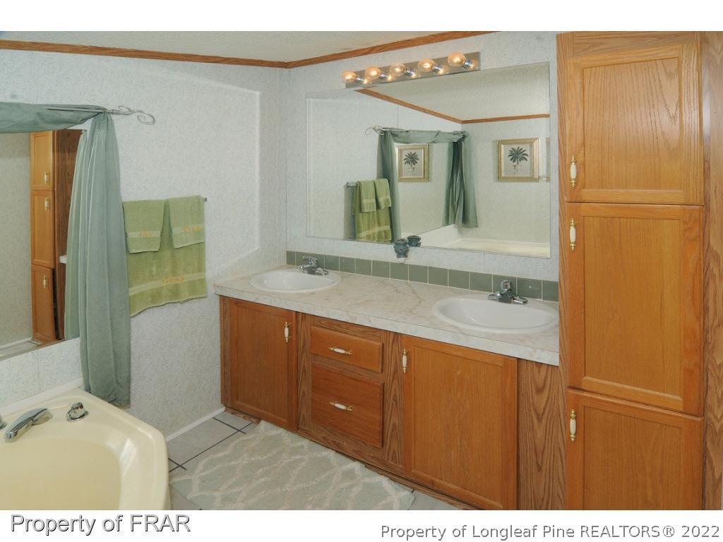 5117 Maxwell Road Stedman, NC 28391 - Photo 7 of 20 a bathroom with a sink a mirror and a bathtub