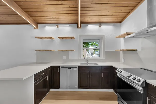 a kitchen with stainless steel appliances granite countertop a sink stove and cabinets