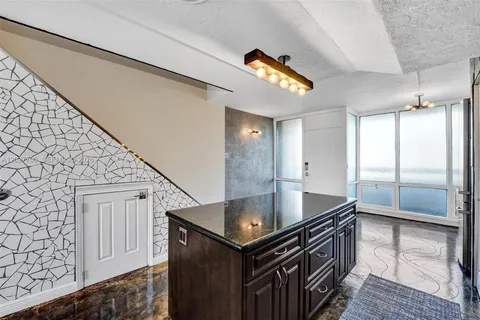 a kitchen with stainless steel appliances granite countertop a sink a stove and a refrigerator