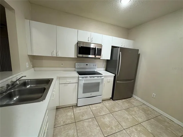 a kitchen with a sink a stove a microwave and refrigerator