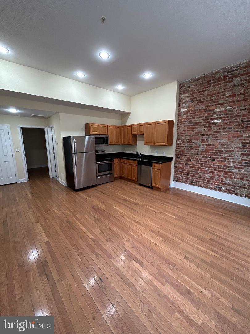 106 North Eutaw Street, Unit 3A Baltimore, MD 21201 - Photo 2 of 6 a open kitchen with stainless steel appliances granite countertop a large counter top