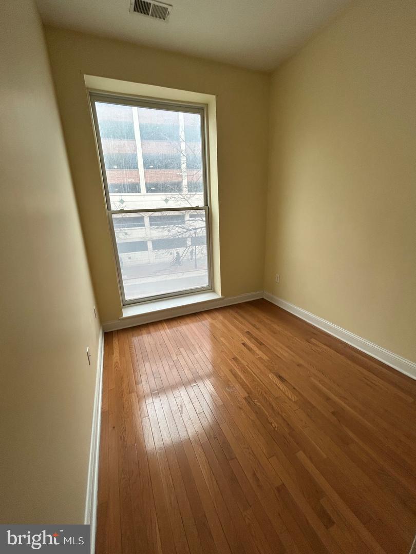 106 North Eutaw Street, Unit 3A Baltimore, MD 21201 - Photo 4 of 6 an empty room with wooden floor and windows