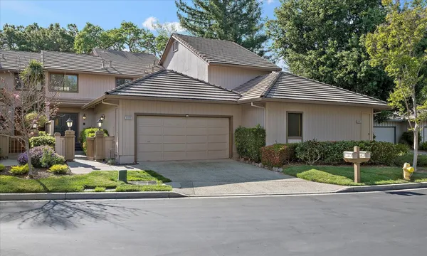 front view of house with a yard and potted plants