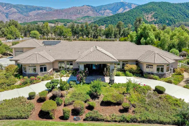 an aerial view of a house with a big yard and garden