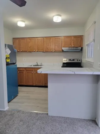 a kitchen with stainless steel appliances a sink a stove a microwave a sink and cabinets
