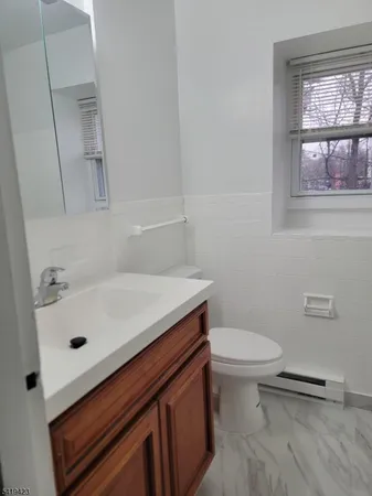 a bathroom with a sink a toilet and a window
