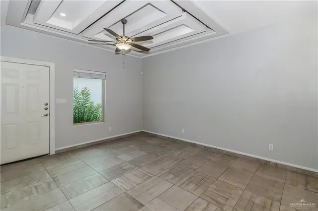 an empty room with a ceiling fan and window