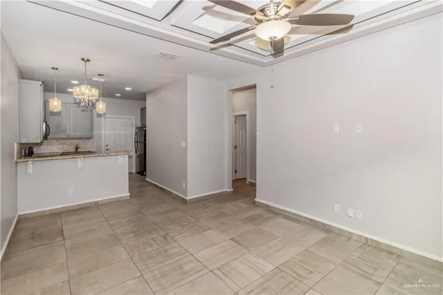 a view of a kitchen with a sink stainless steel appliances furniture and a chandelier