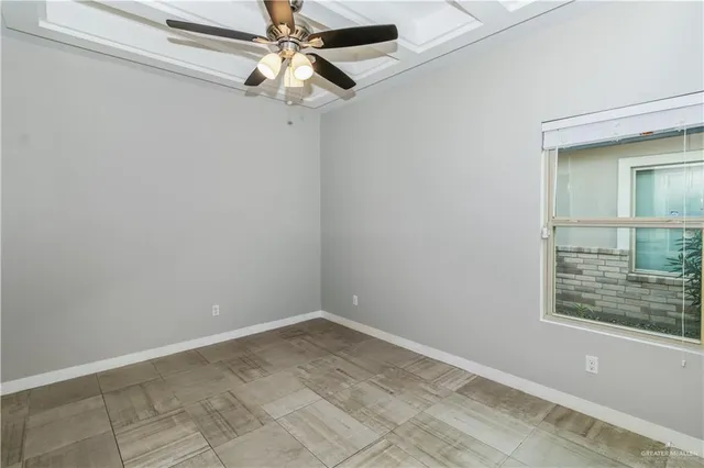 an empty room with a window and a fan