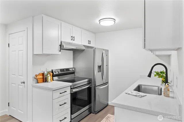 a kitchen with stainless steel appliances granite countertop a sink stove and refrigerator