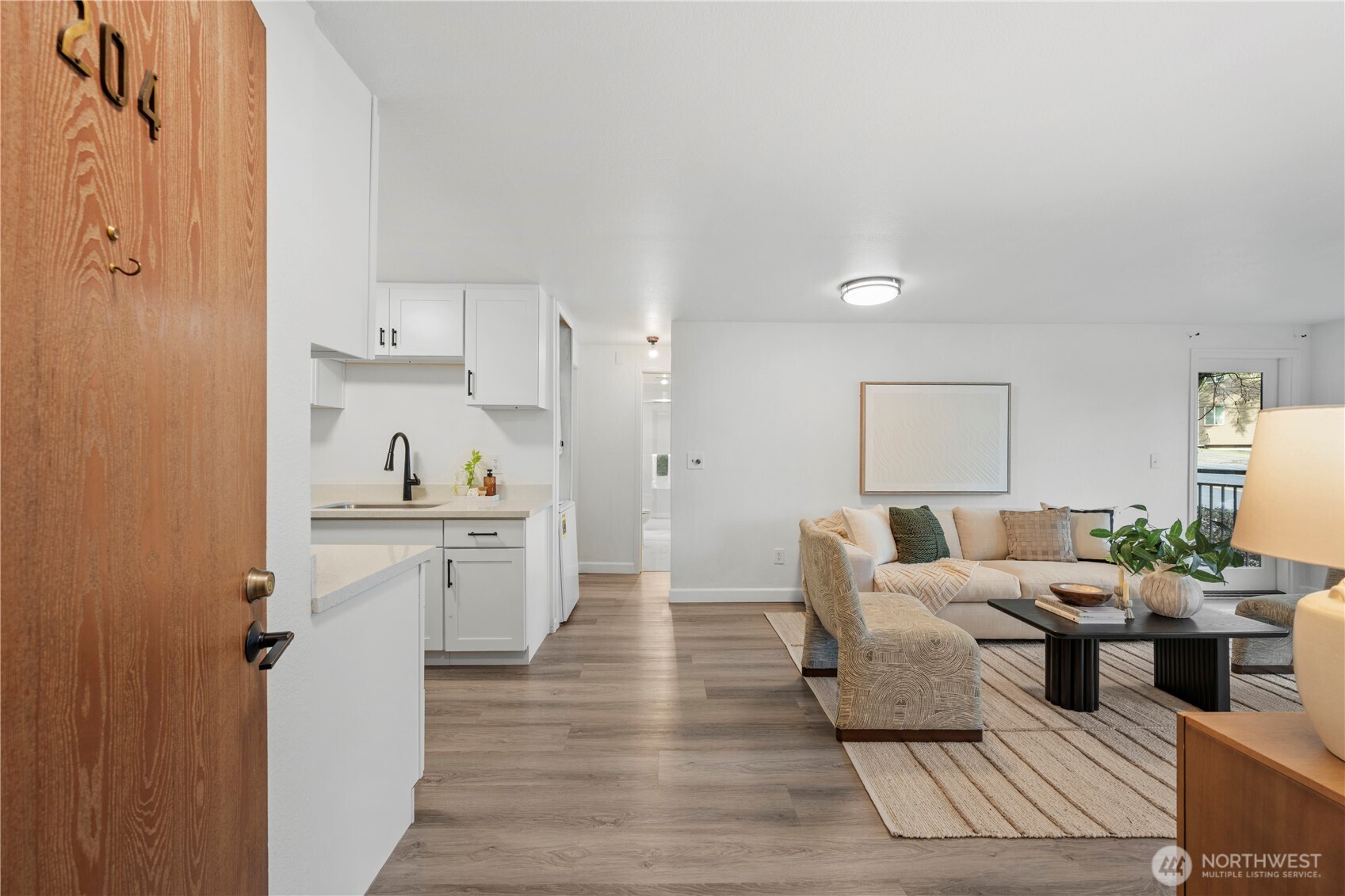 707 North 130th Street, Unit B204 Seattle, WA 98133 - Photo 5 of 21 a living room with furniture and a wooden floor