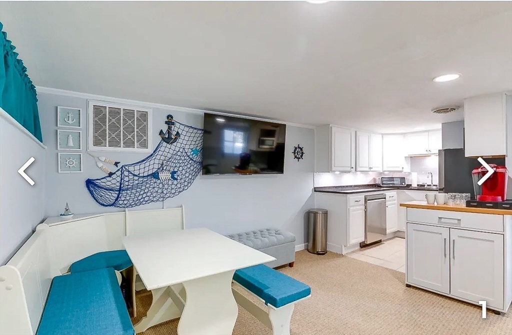 8 Franklin Street, Unit 19 Marblehead, MA 01945 - Photo 3 of 6 a living room with furniture a flat screen tv and kitchen view