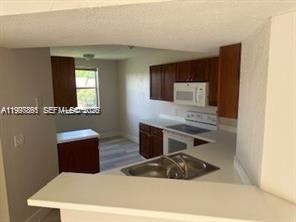 Pine Ridge Coral Springs, FL 33067 - Photo 2 of 3 a kitchen with a refrigerator and a stove top oven