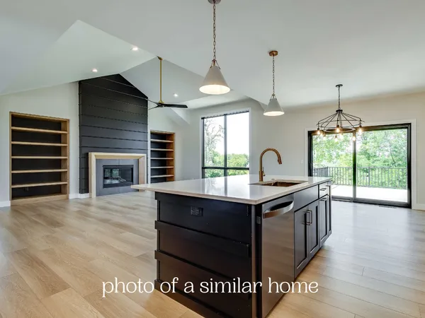 a kitchen with stainless steel appliances granite countertop a stove a sink and a wooden floors