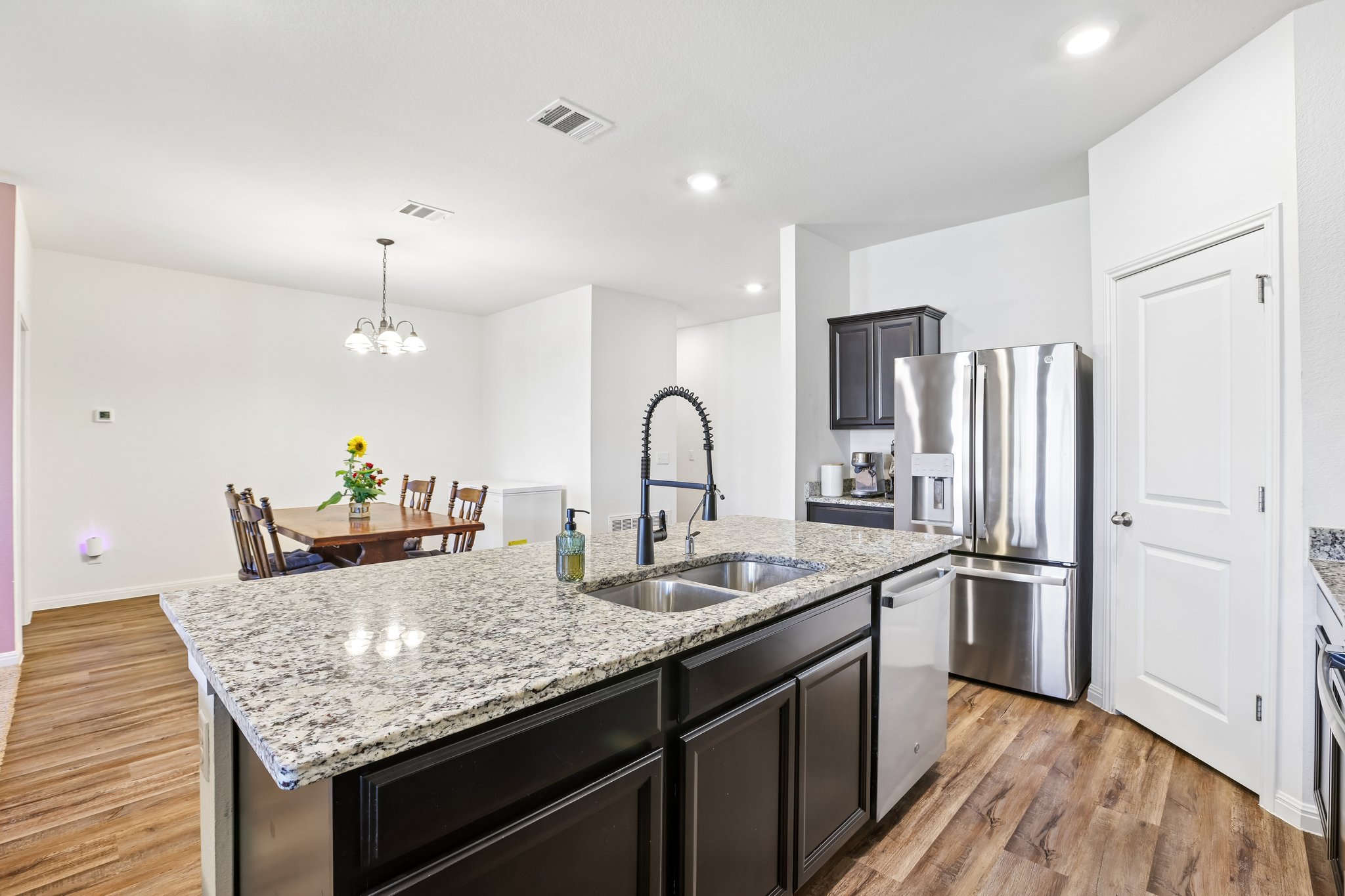 19105 Mike Mansfield Road Manor, TX 78653 - Photo 6 of 28 a kitchen with granite countertop stainless steel appliances a sink and a refrigerator