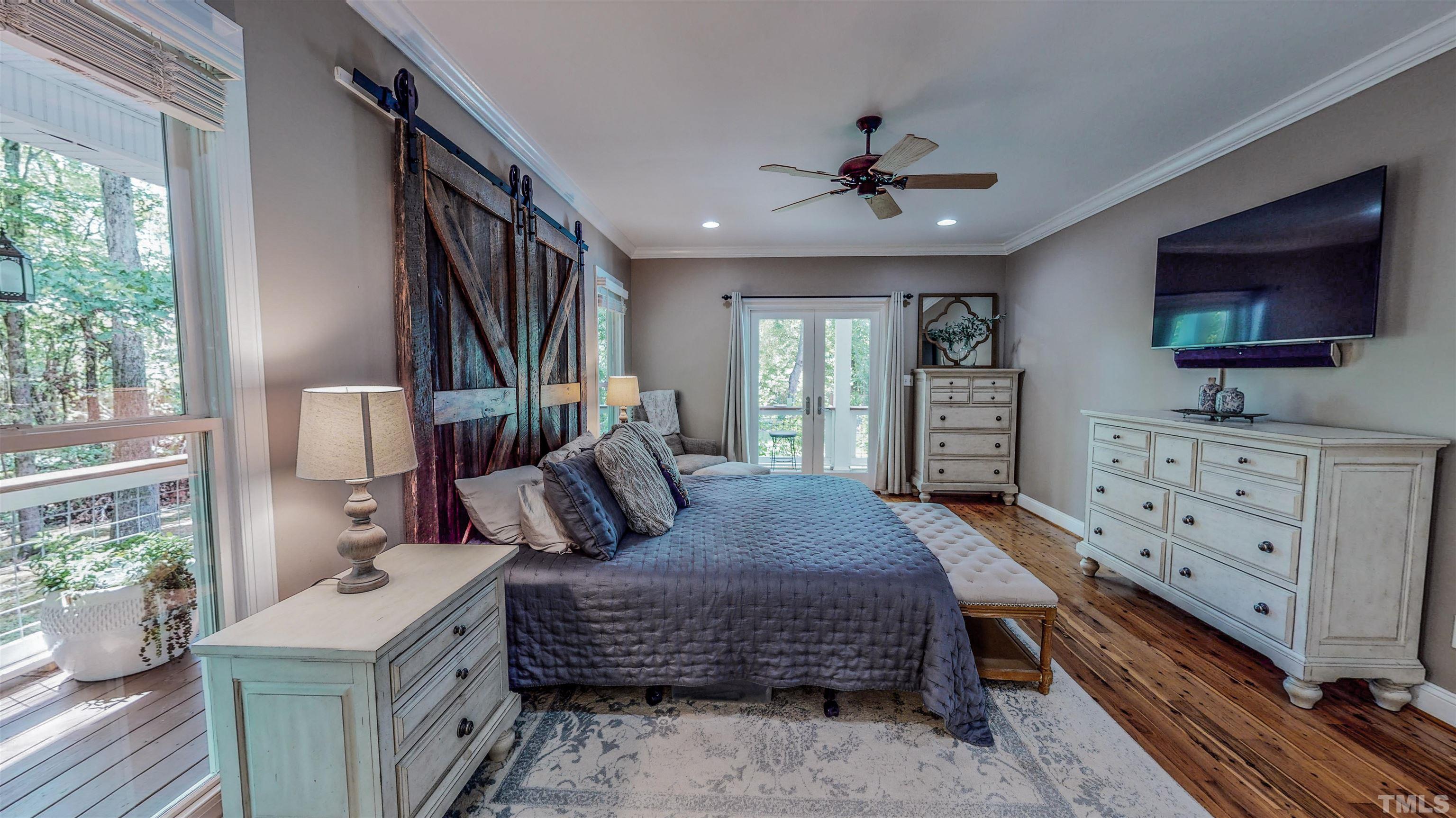 303 Bowen Road Rougemont, NC 27572 - Photo 77 of 85 a bedroom with a bed a flat screen tv and a large window with the outer view