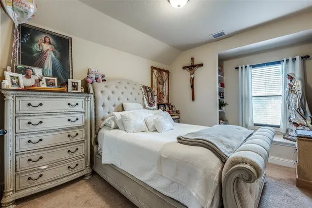 a bedroom with a bed and a mirror on the dresser