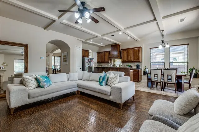 a living room with furniture kitchen view and a large window