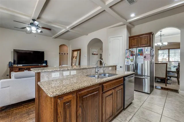 a kitchen with stainless steel appliances granite countertop a sink dishwasher stove and refrigerator with wooden floor