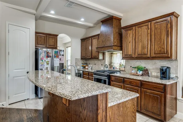 a kitchen with stainless steel appliances granite countertop a kitchen island a stove a sink dishwasher and cabinets with wooden floor