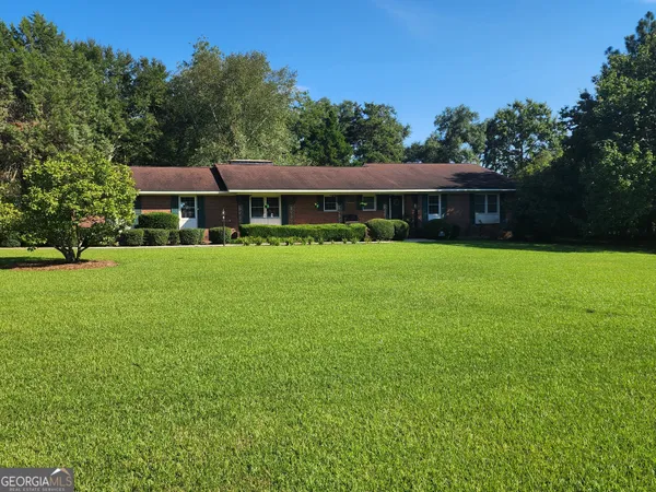 a front view of house with yard and green space