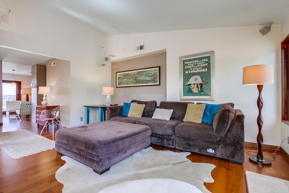 428 Compass Road Oceanside, CA 92054 - Photo 4 of 21 a spacious bedroom with a bed a couch and paintings on the wall