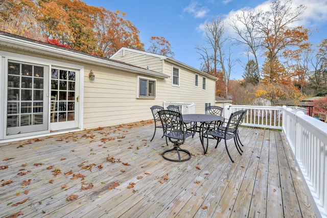 a view of a roof deck with table and chairs and wooden floor