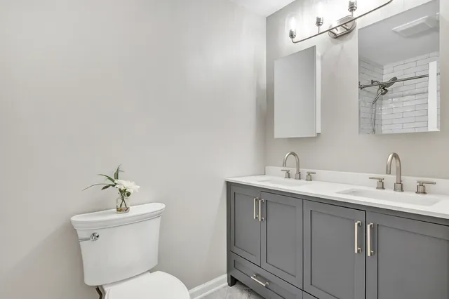 a bathroom with a toilet a sink and mirror