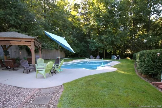 a view of backyard with table and chairs and potted plants