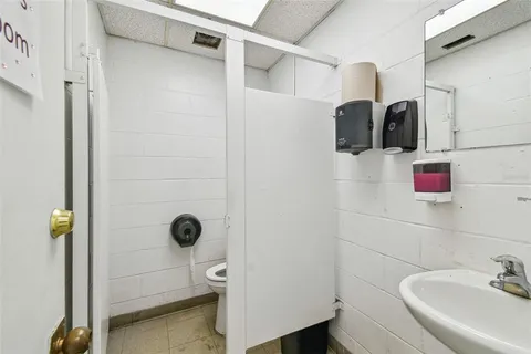 a room with stainless steel appliances kitchen island a table chairs and refrigerator