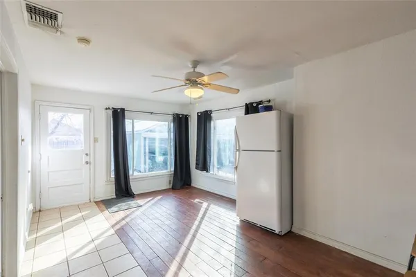a view of an empty room with window and wooden floor