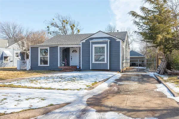 a view of a house with snow on the side of the road