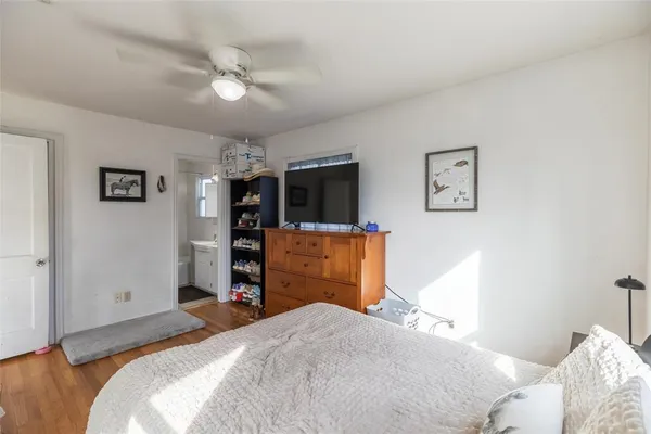 a bedroom with a bed and a flat tv screen on dresser