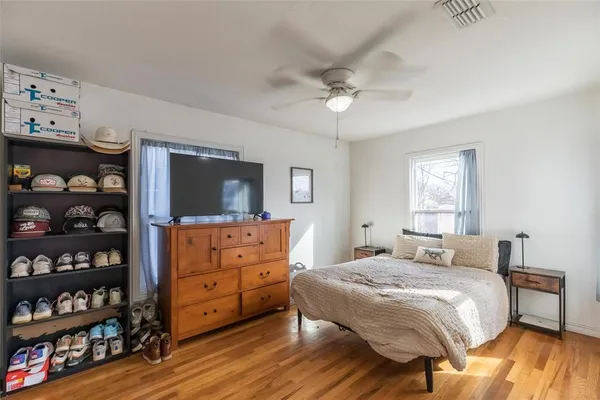 a bedroom with a bed and a flat tv screen on dresser