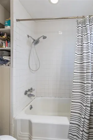 a bathroom with a bath tub with a shower