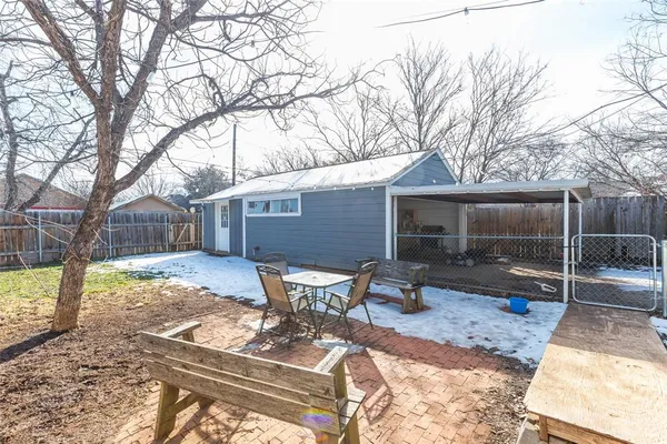 a backyard of a house with table and chairs