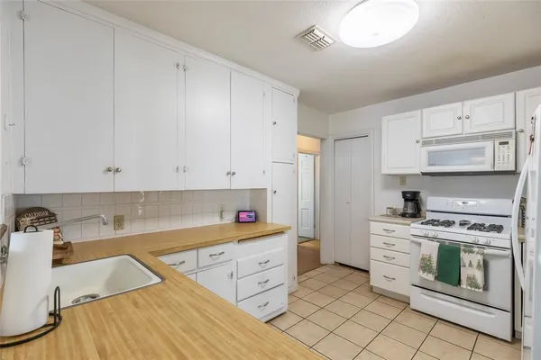 a kitchen with white cabinets and white appliances