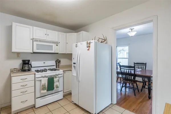 a kitchen with cabinets stainless steel appliances and a dining table