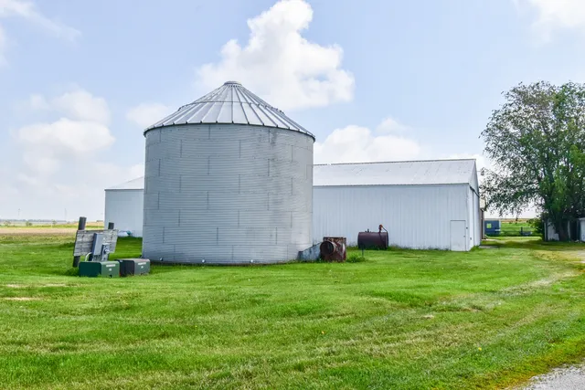 a white house that has tree in front of it