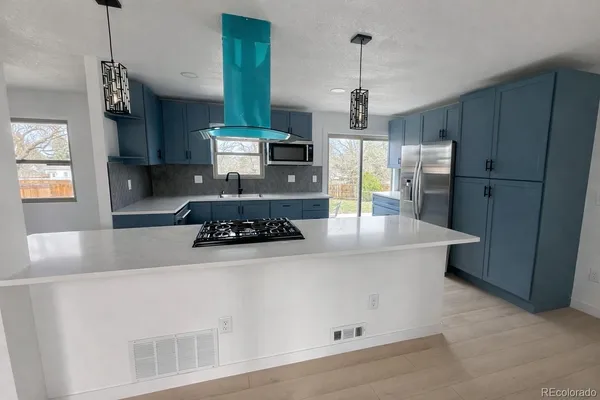 a kitchen with stainless steel appliances a stove a refrigerator and a sink