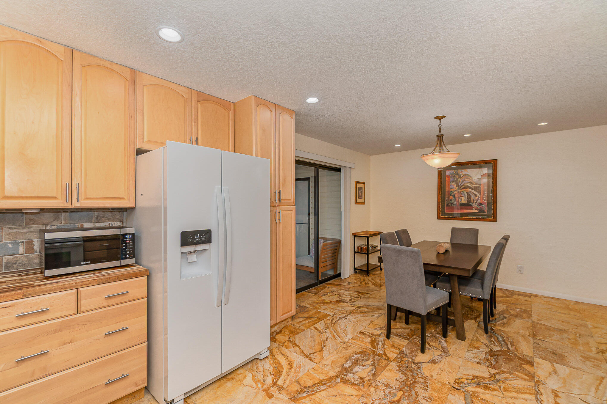 2114 Manor Drive Northeast Palm Bay, FL 32905 - Photo 16 of 24 a kitchen with refrigerator cabinets dining table and chairs