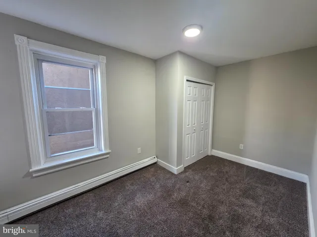 an empty room with windows and closet