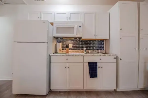 a kitchen with white cabinets and white appliances