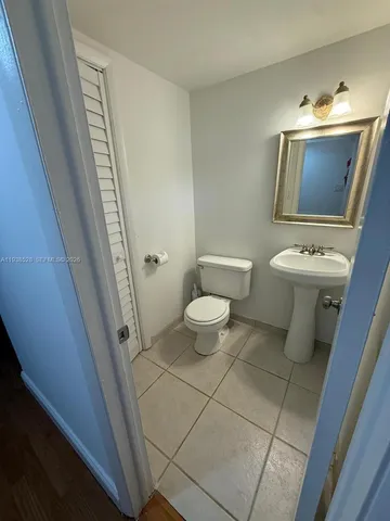 a bathroom with a toilet a sink a mirror and vanity