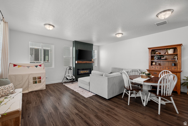 1708 North 1280th Street East Payson, UT 84651 - Photo 5 of 15 Open-concept living space featuring wood-finish flooring, flush mount lighting through out, and a modern fireplace with a dark paneled surround and wood mantel