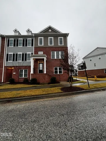 a view of building with parking space and a car parked in front of it