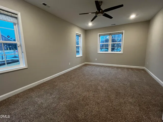en empty room with windows and ceiling fan view